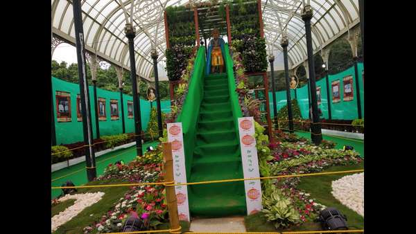 ಗಾಜಿನ ಮನೆ ಬಳಿ ಆಕರ್ಷಕ ಪುಷ್ಪ ಜೋಡಣೆ