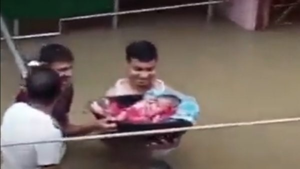 Father brought a newborn baby in Assam flood - people compared the scene to Krishna Father brought a newborn baby in Assam flood - people compared the scene to Krishna